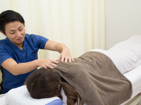 肩の施術を行う男性スタッフ